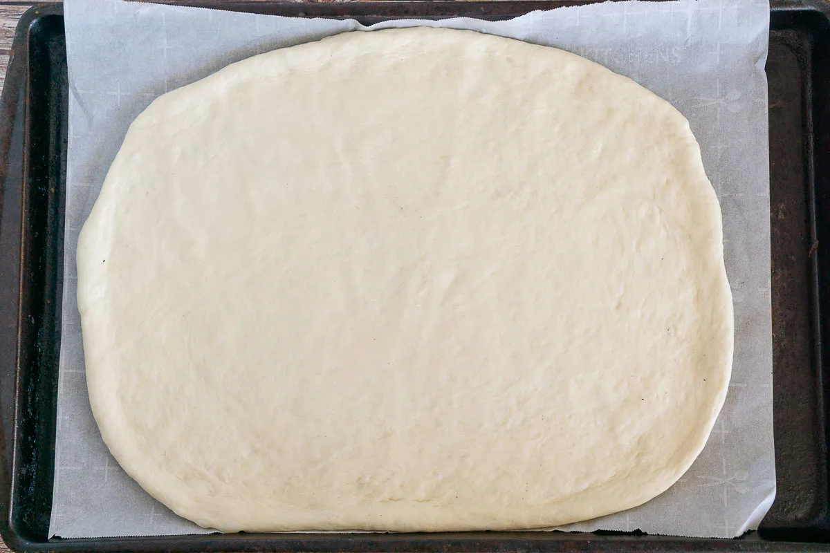 Pizza dough rolled out in a pan