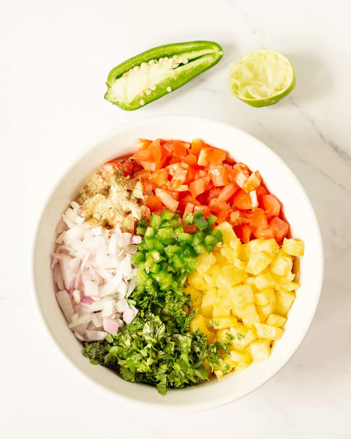Bowl with diced ingredients for pineapple pico de gallo