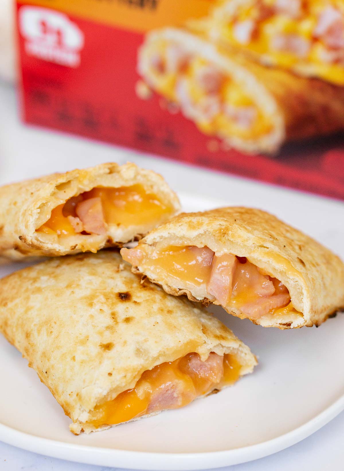 Hot pockets cooked in the air fryer on a plate with the box behind it.