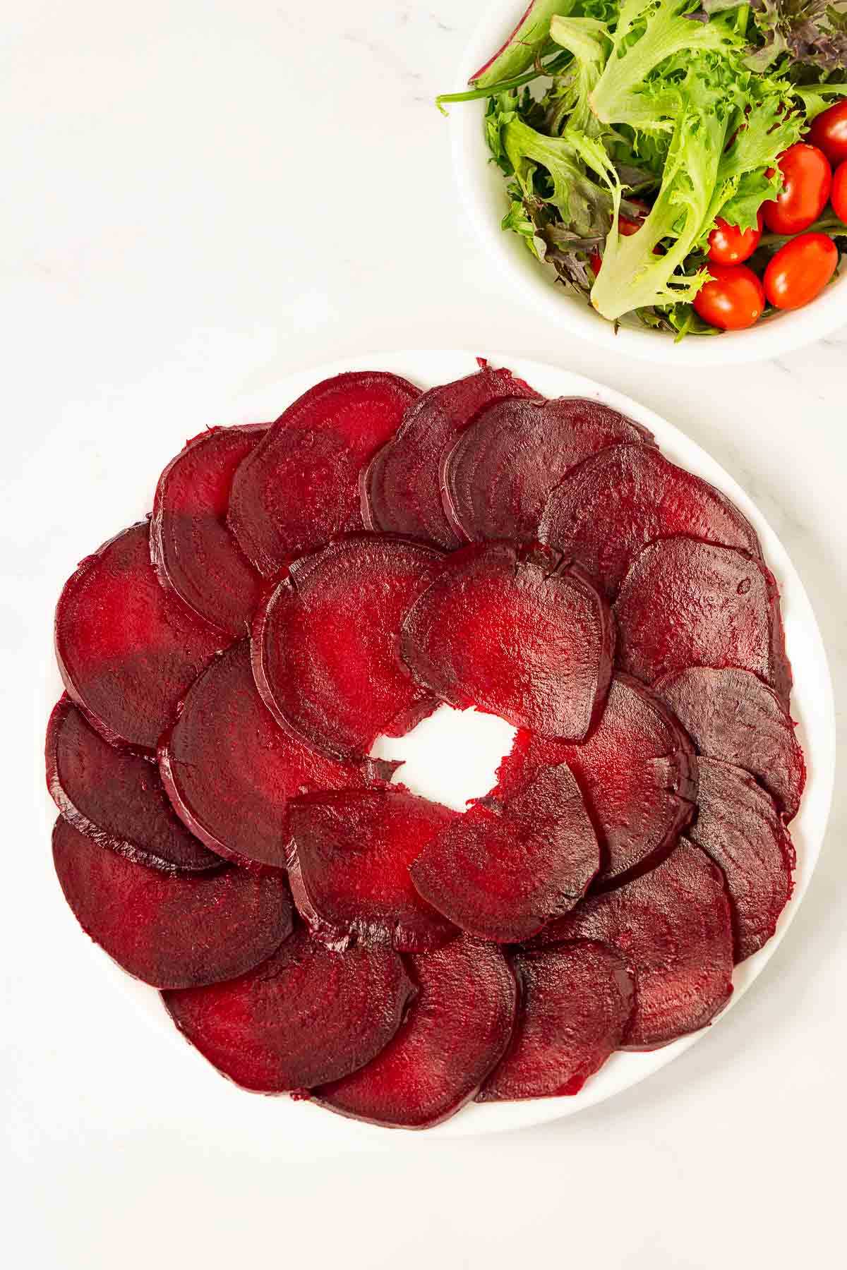 Thinly sliced beets arranged on a plate