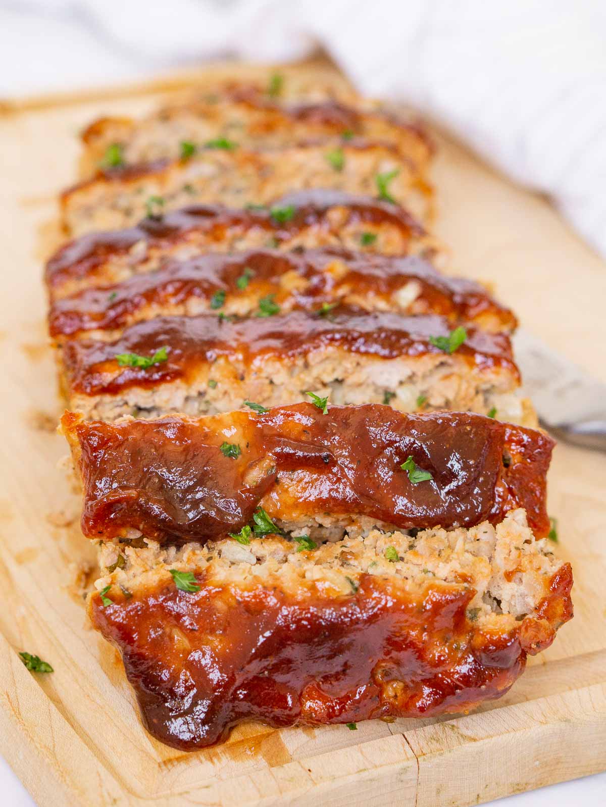 Ground pork meatloaf with glaze on a cutting board