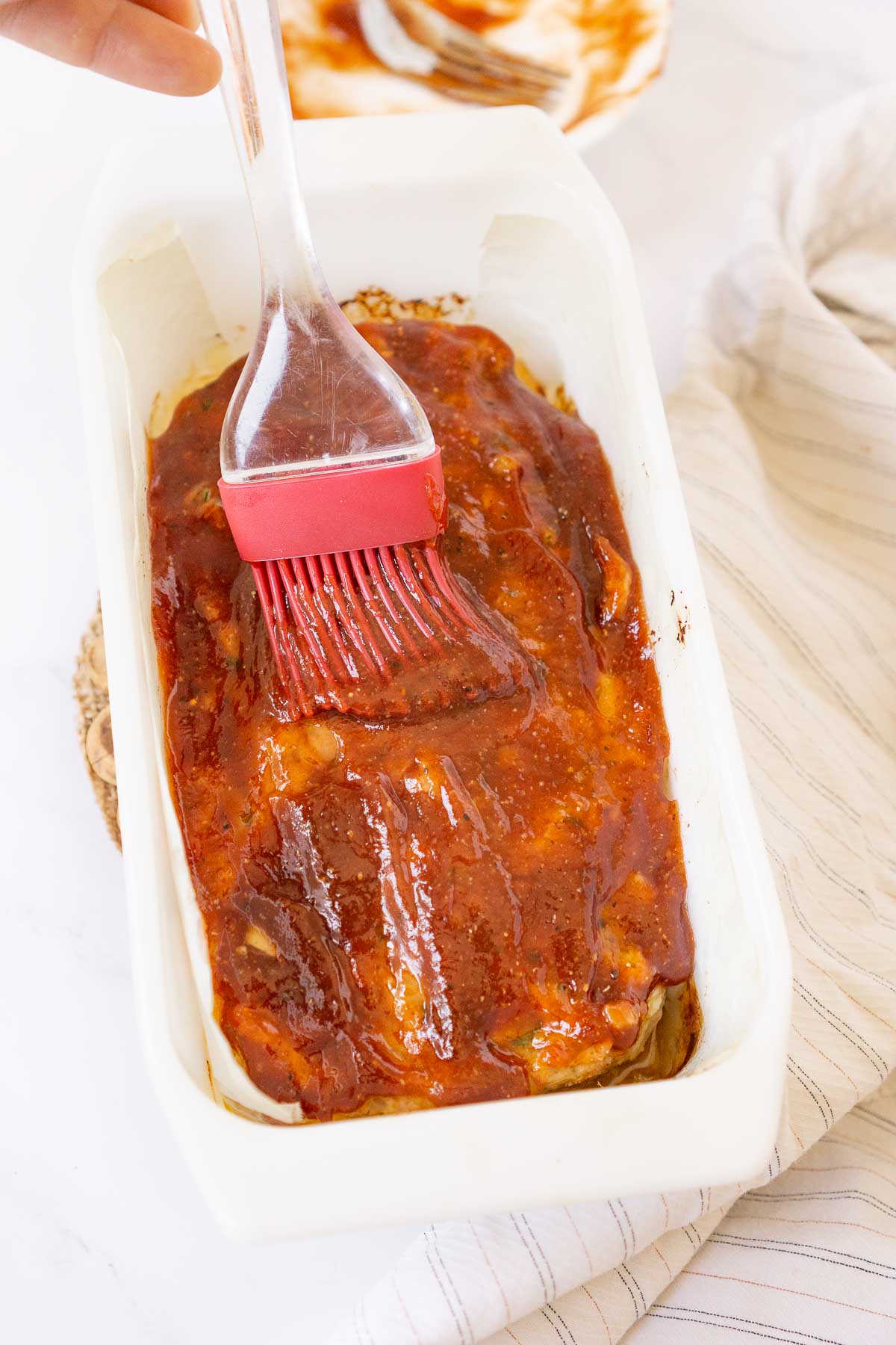 Brushing glaze on pork meatloaf