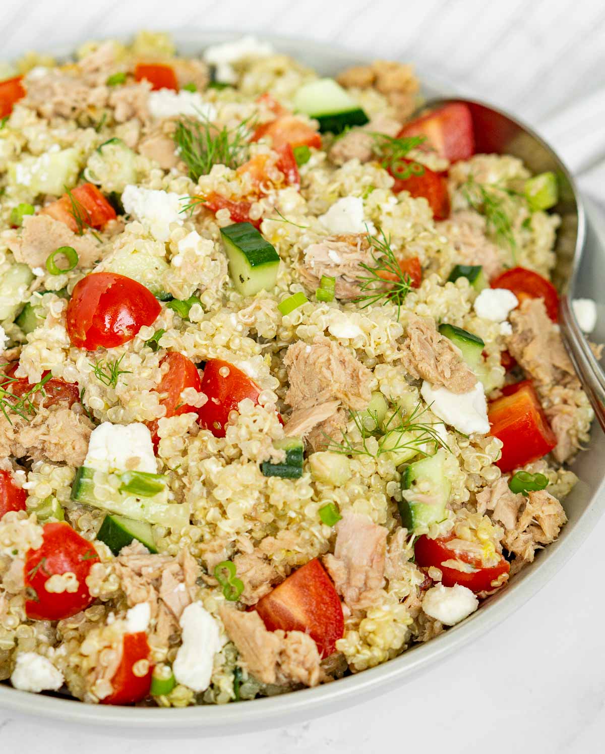 Bowl of quinoa tuna salad with veggies and feta.