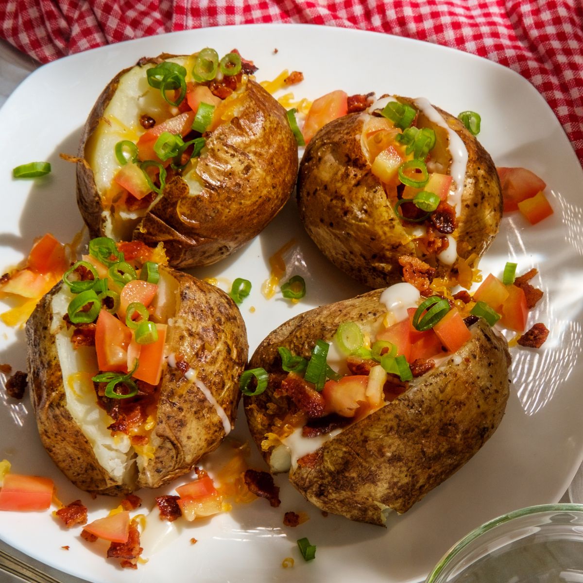 Baked potatoes topped with fresh tomato and herbs