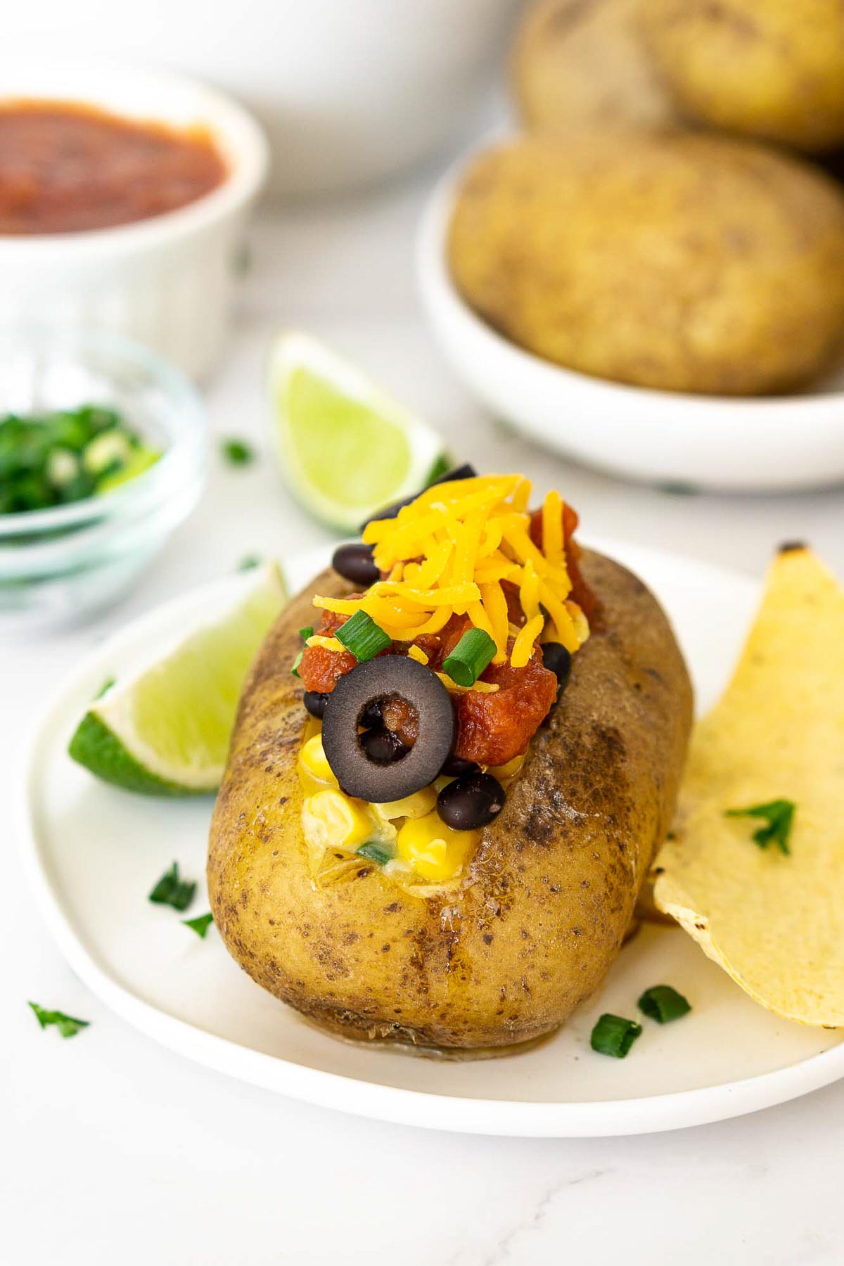 Baked potato loaded with salsa, black beans, olives, and cheese
