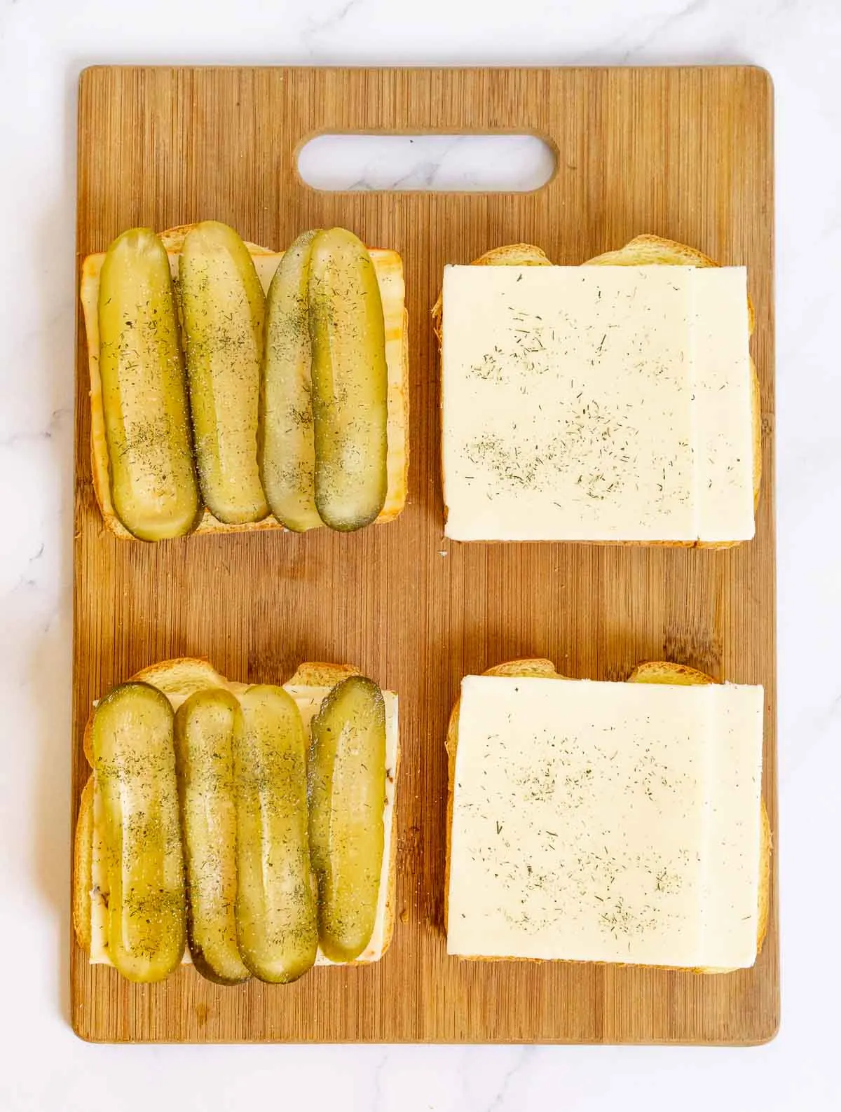 Sliced cheese and sliced pickles on bread