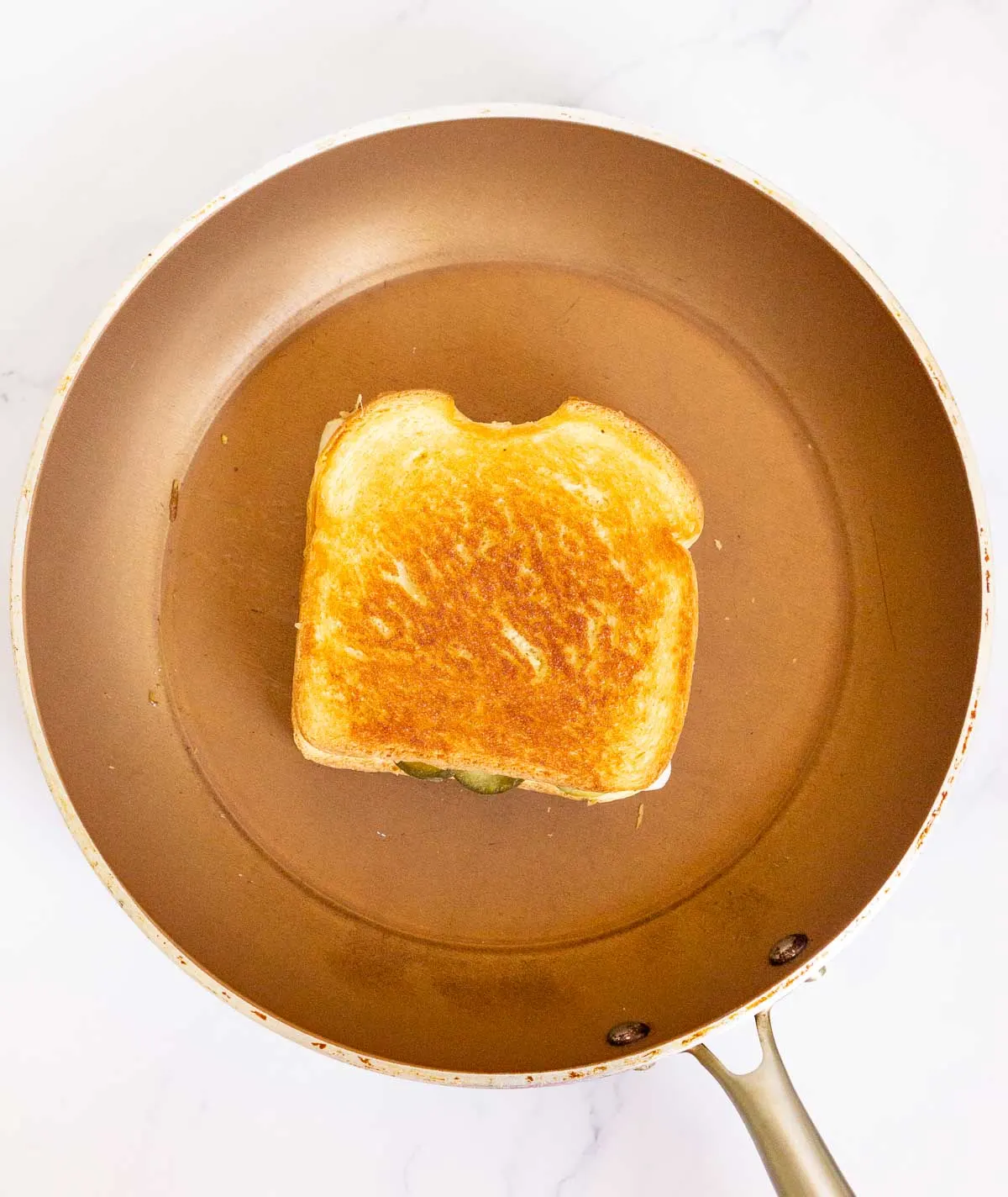 Grilled cheese sandwich toasting in a pan