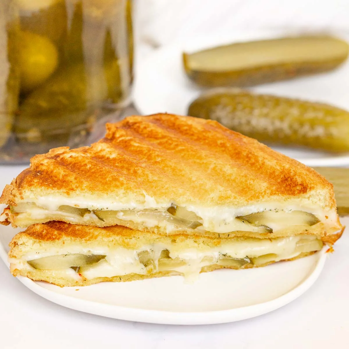 Grilled cheese sandwich with pickles on a plate