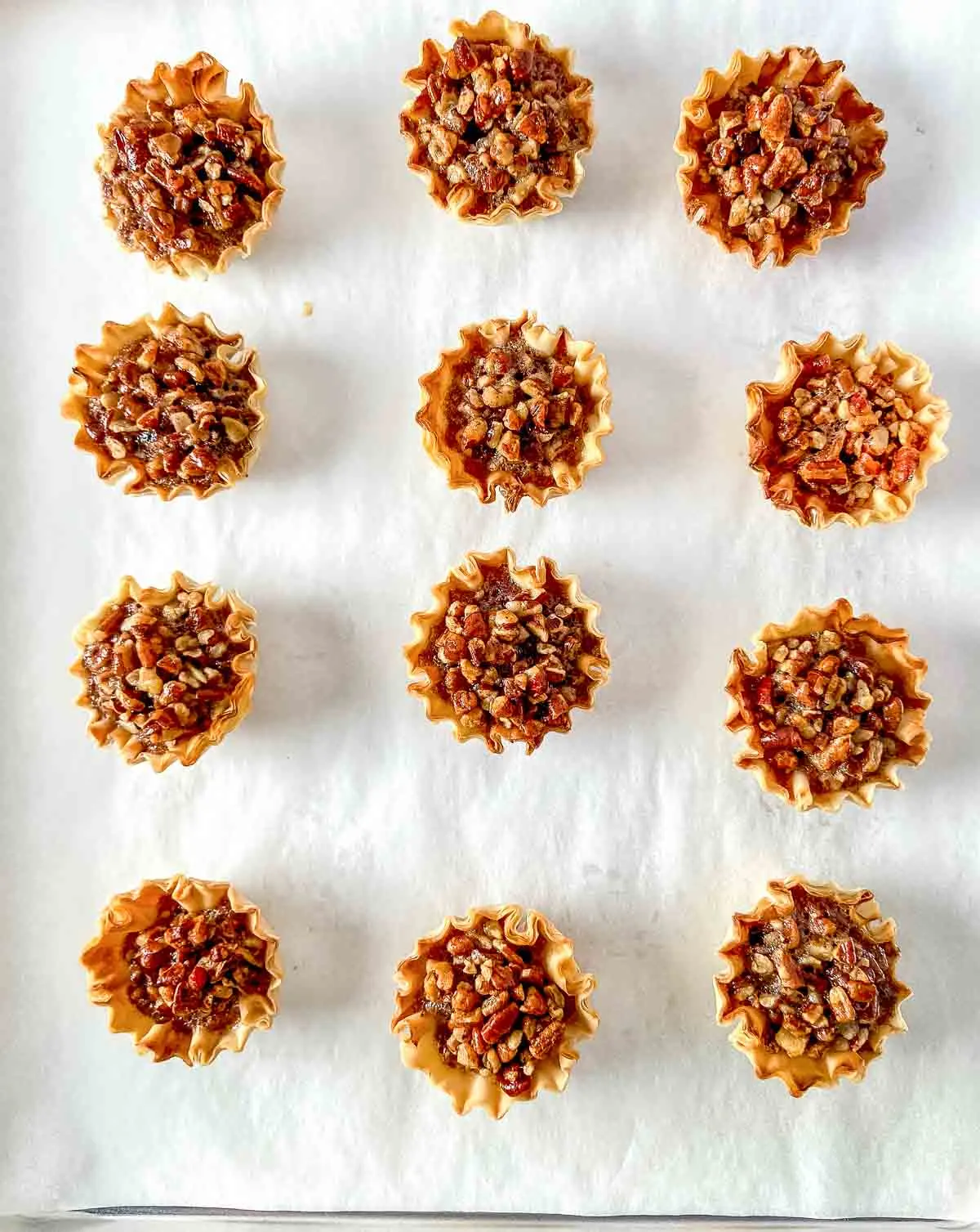 Phyllo cups with pecan pie filling on parchment paper