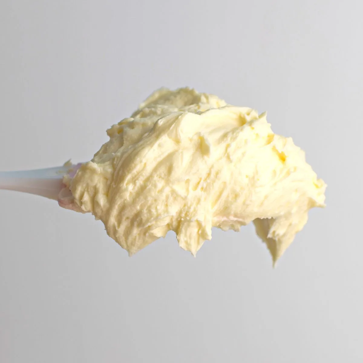 Champagne buttercream frosting on a spoon