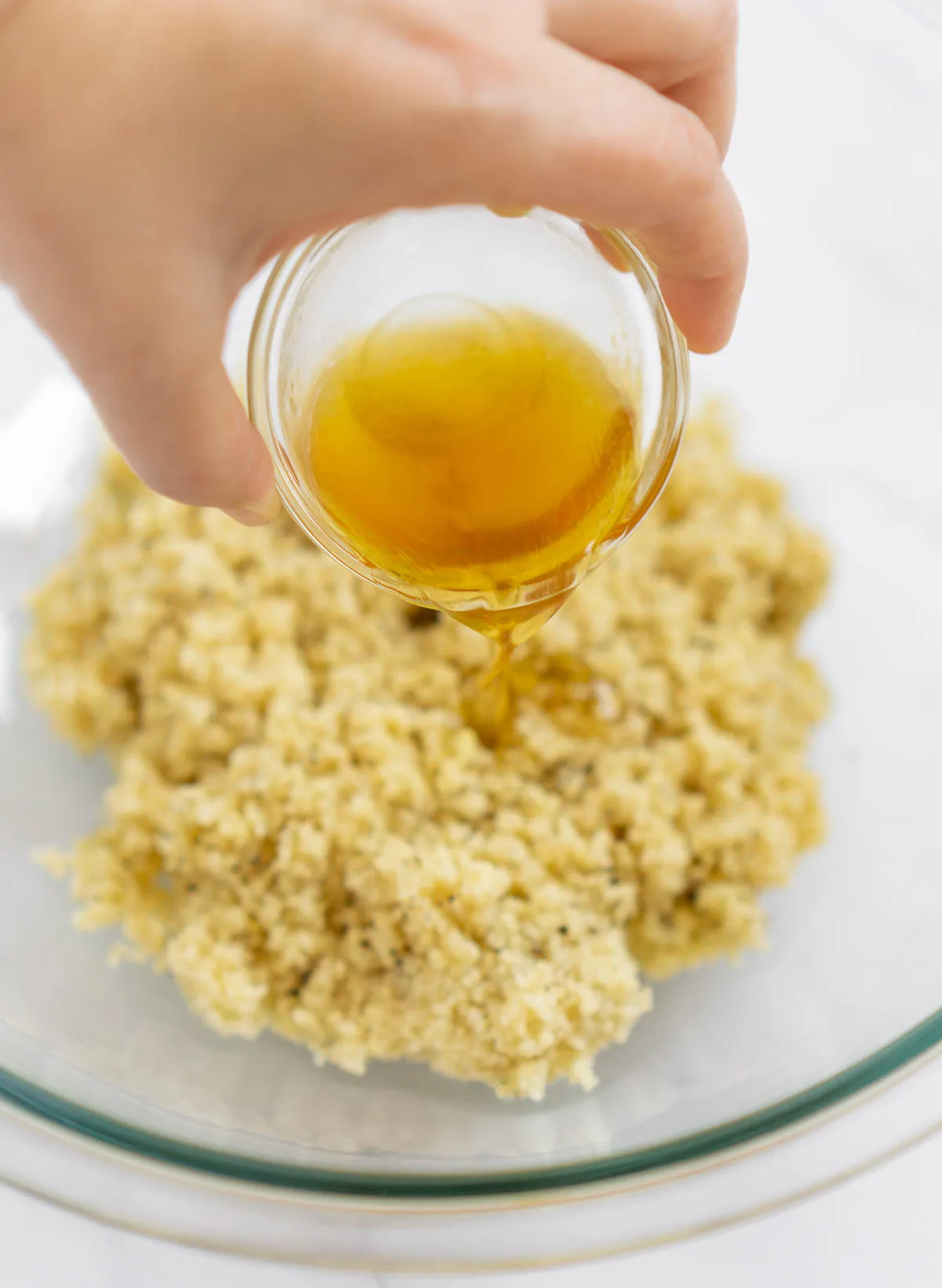Adding lemon juice, maple syrup, and olive oil to couscous