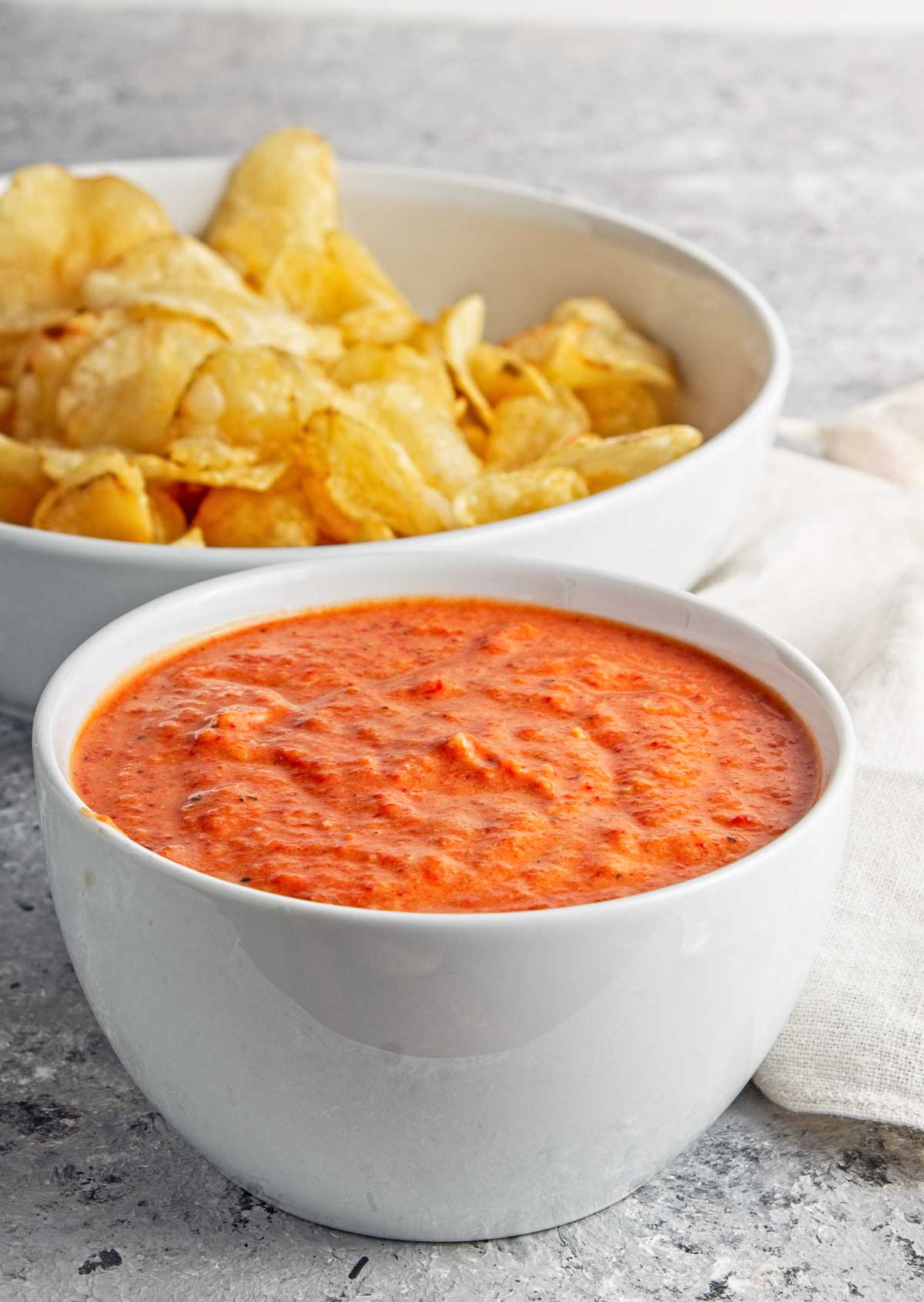 Bowl of roasted red pepper dip with chips