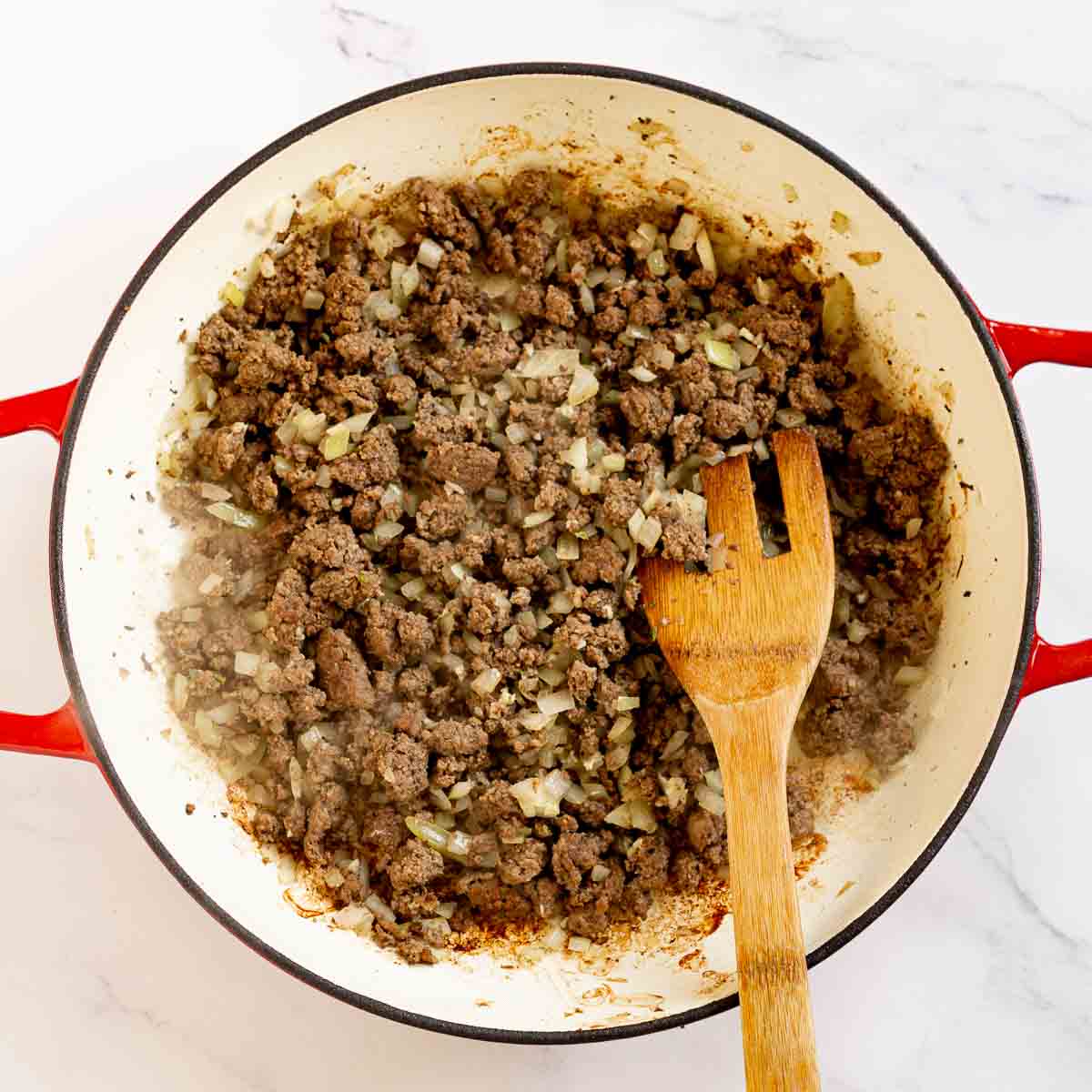 Diced onion sauteed with ground beef in a pan