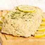 Fish loaf on a cutting board garnished with lemon and dill
