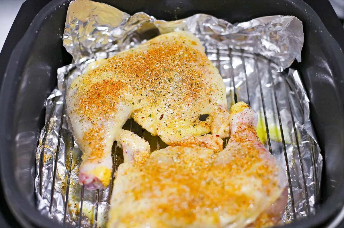 Seasoned chicken leg quarters in an air fryer