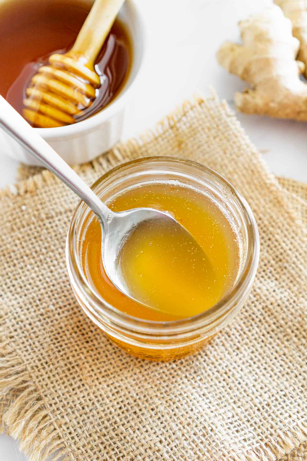 Spoon in a jar of honey ginger syrup