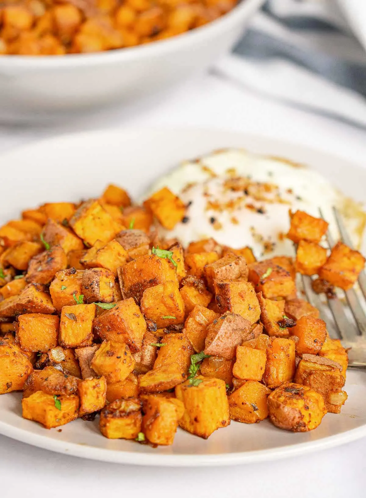 Plate of air fryer sweet potato home fries with a fried egg