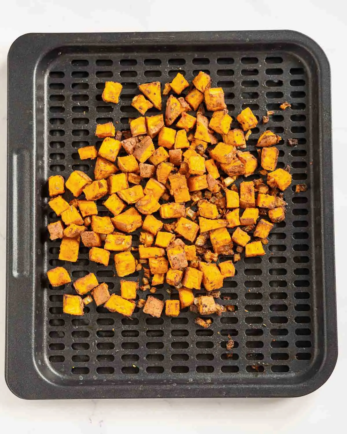 Air fried sweet potato home fries on an air fryer tray