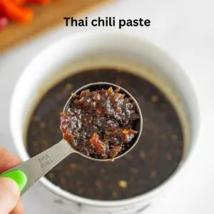 Adding Thai chili paste to a bowl of stir fry sauce