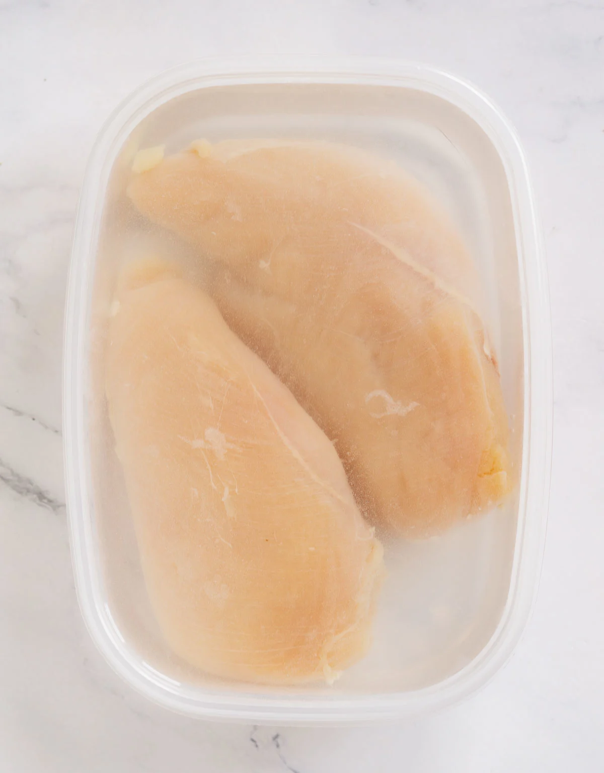 Brining two chicken breasts in a container
