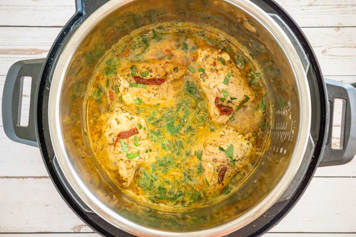 Instant Pot with chicken thighs in a creamy sun dried tomato sauce