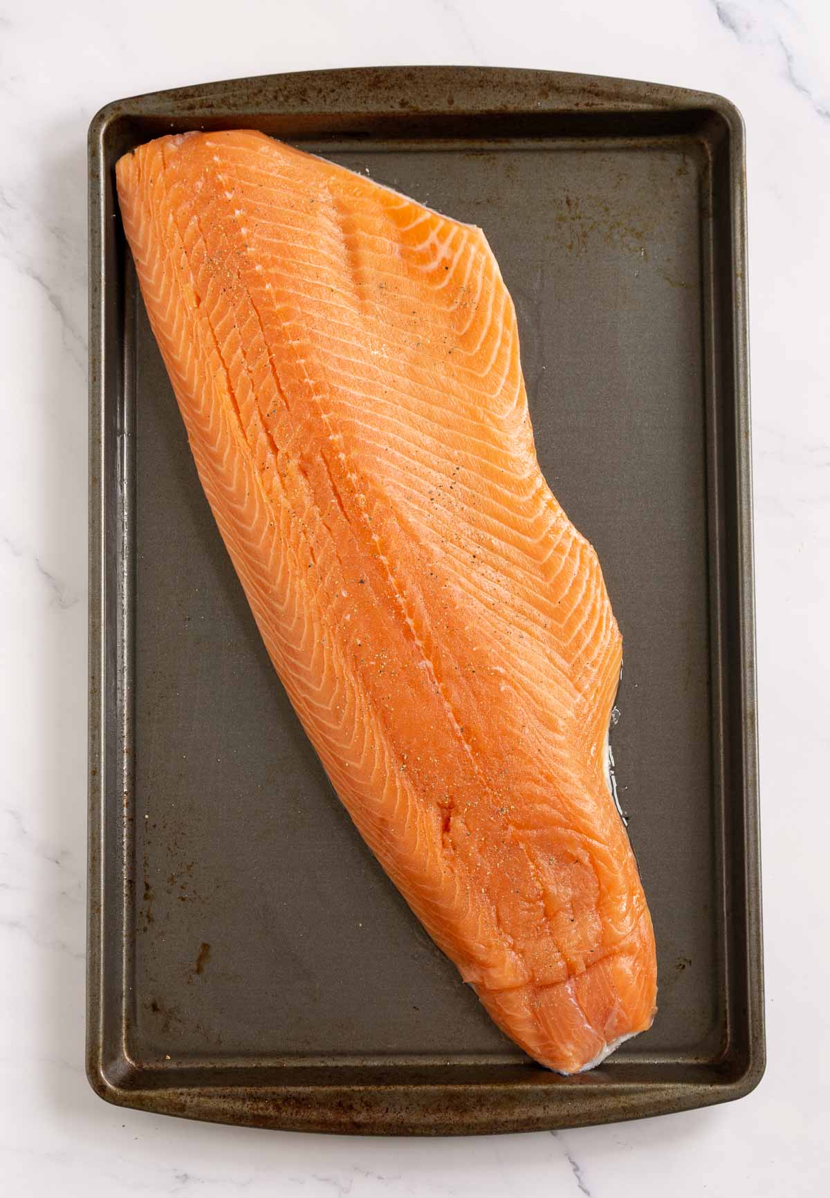Whole salmon fillet seasoned with salt and pepper