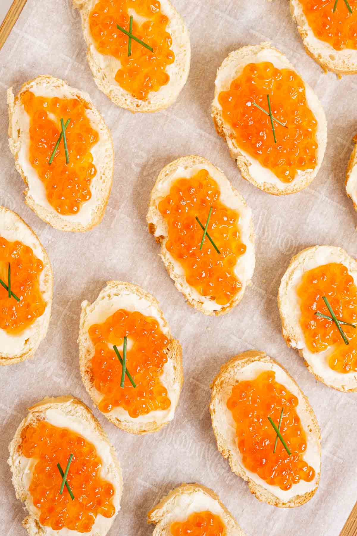Red caviar toasts with chive garnish