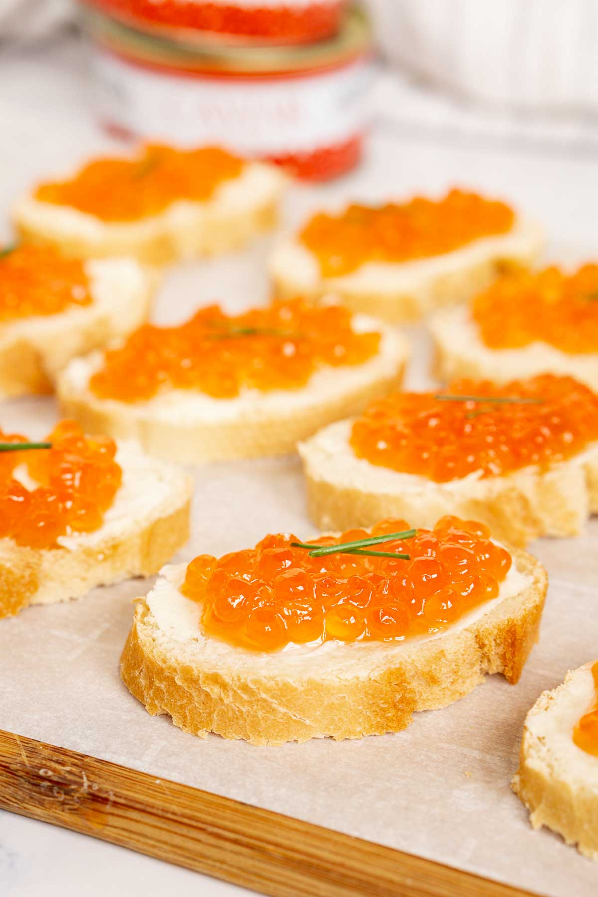 Red caviar toasts on a serving board