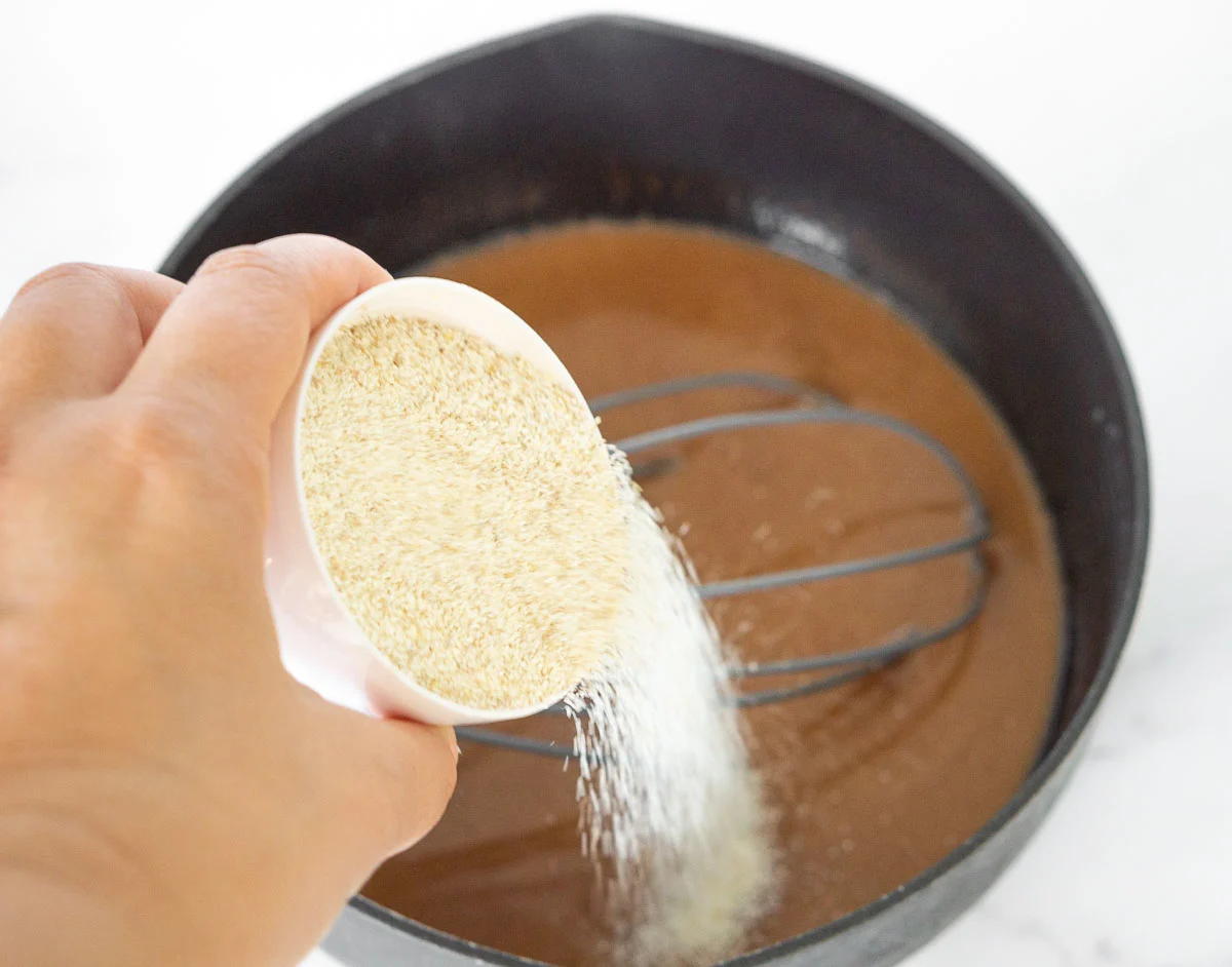Pouring dry cream of wheat into saucepan