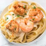 Plate of air fryer chicken and shrimp Alfredo over pasta