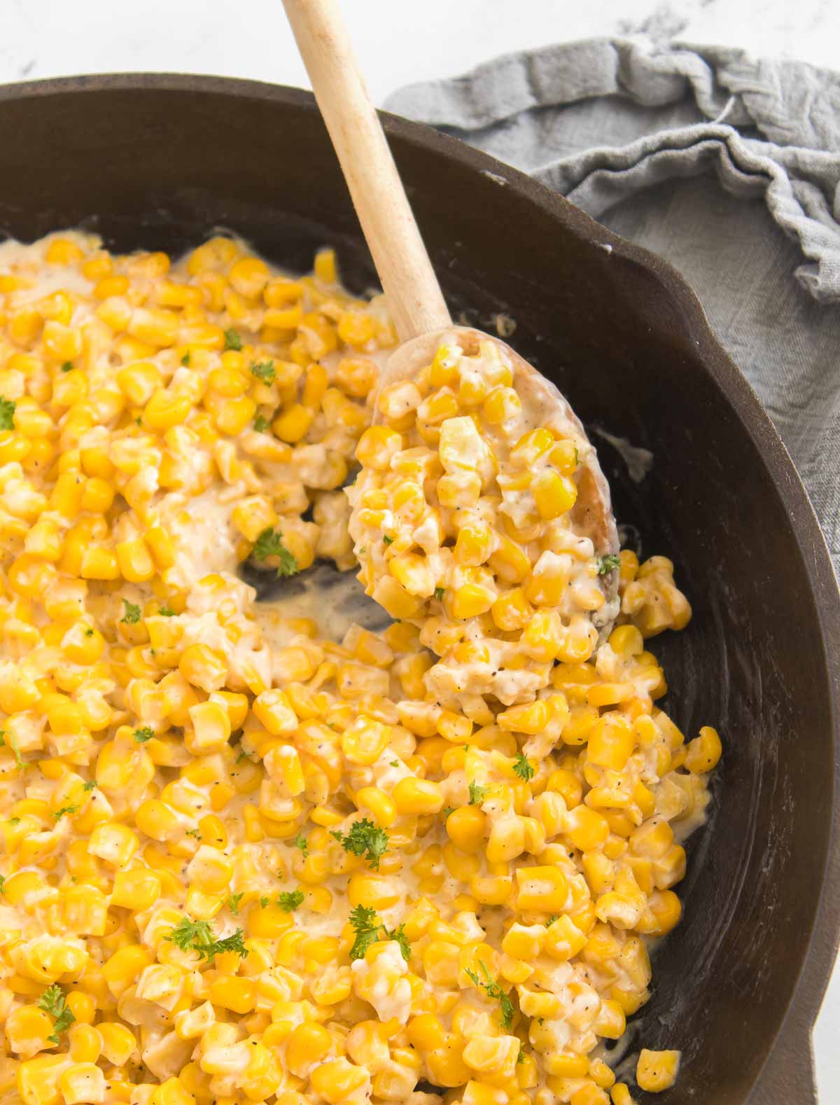 Honey butter skillet corn with a wooden serving spoon.