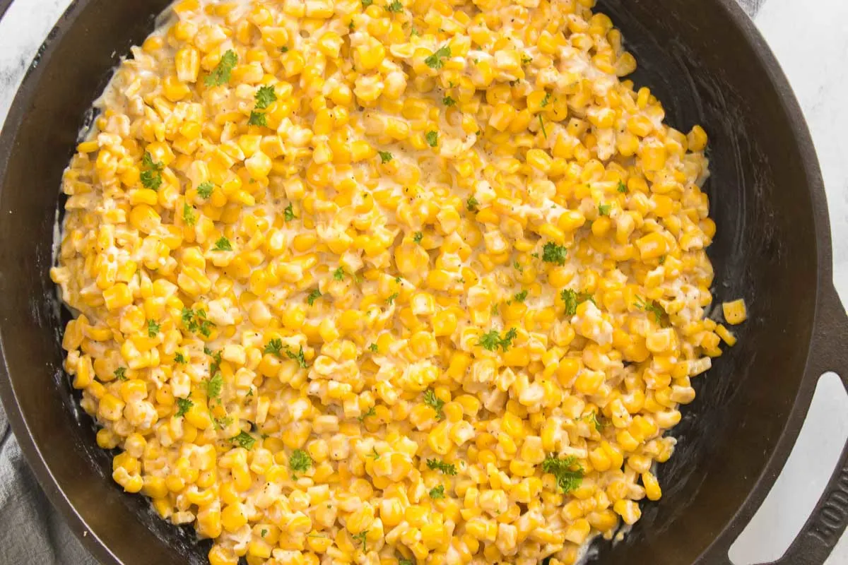 Honey butter corn side dish garnished with parsley.