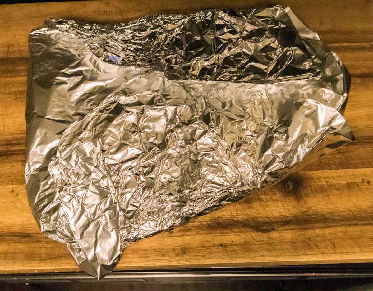 Brisket wrapped in foil to cool