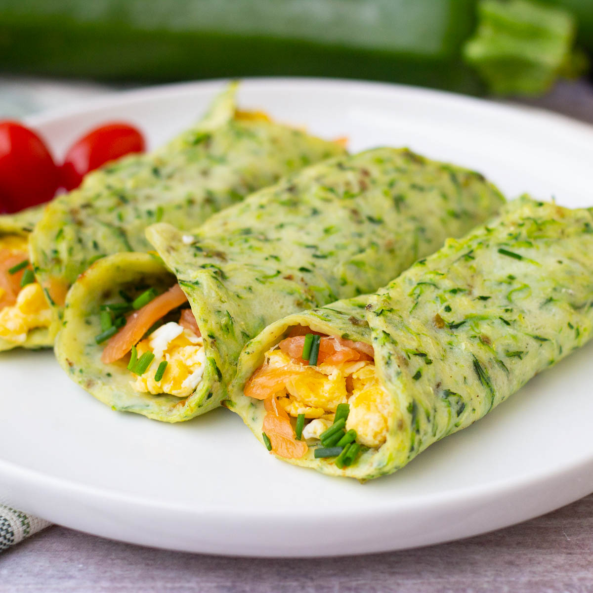 Zucchini breakfast wraps stuffed with egg and lox on a plate