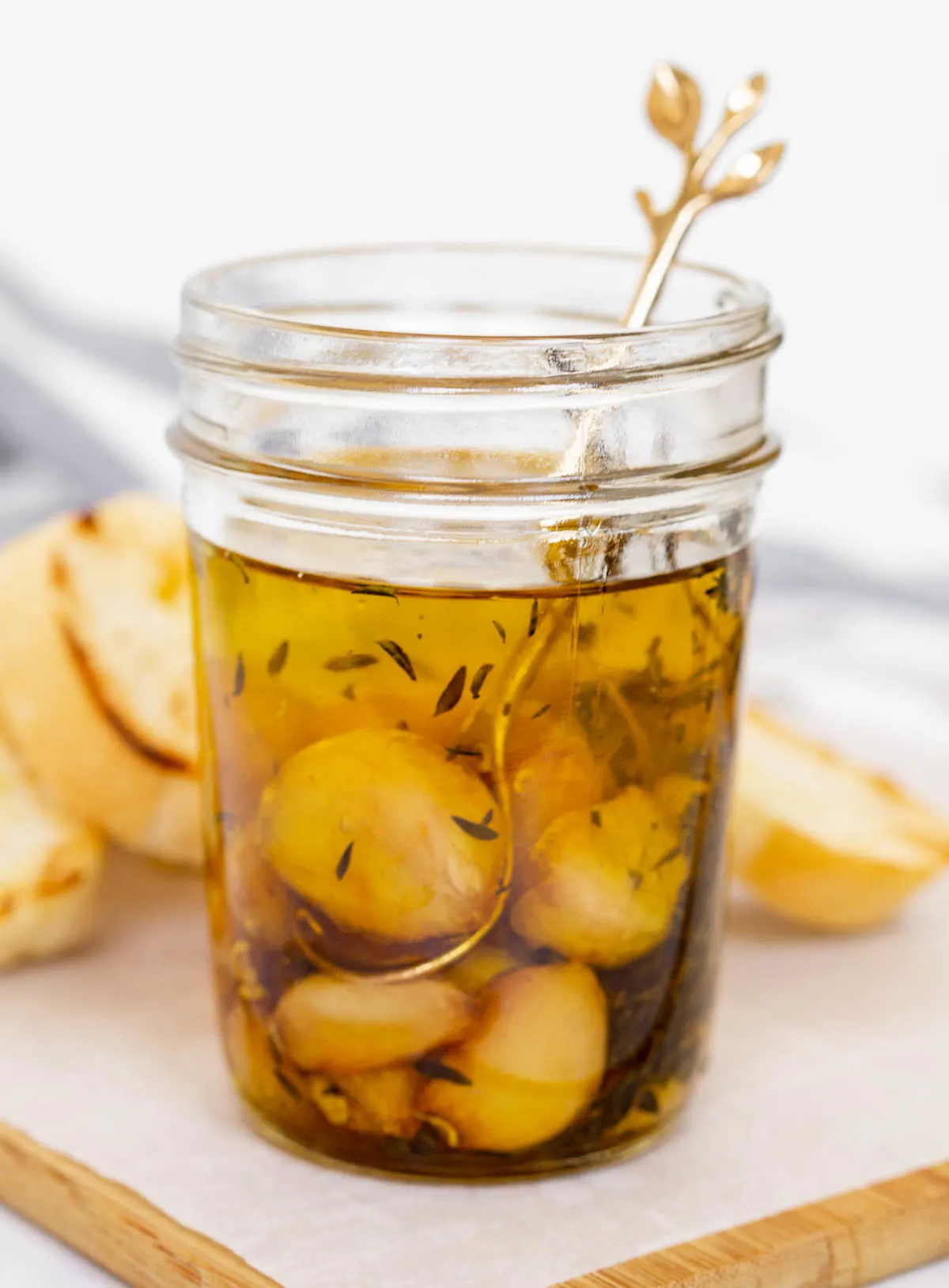 Jar with garlic confit cloves in olive oil