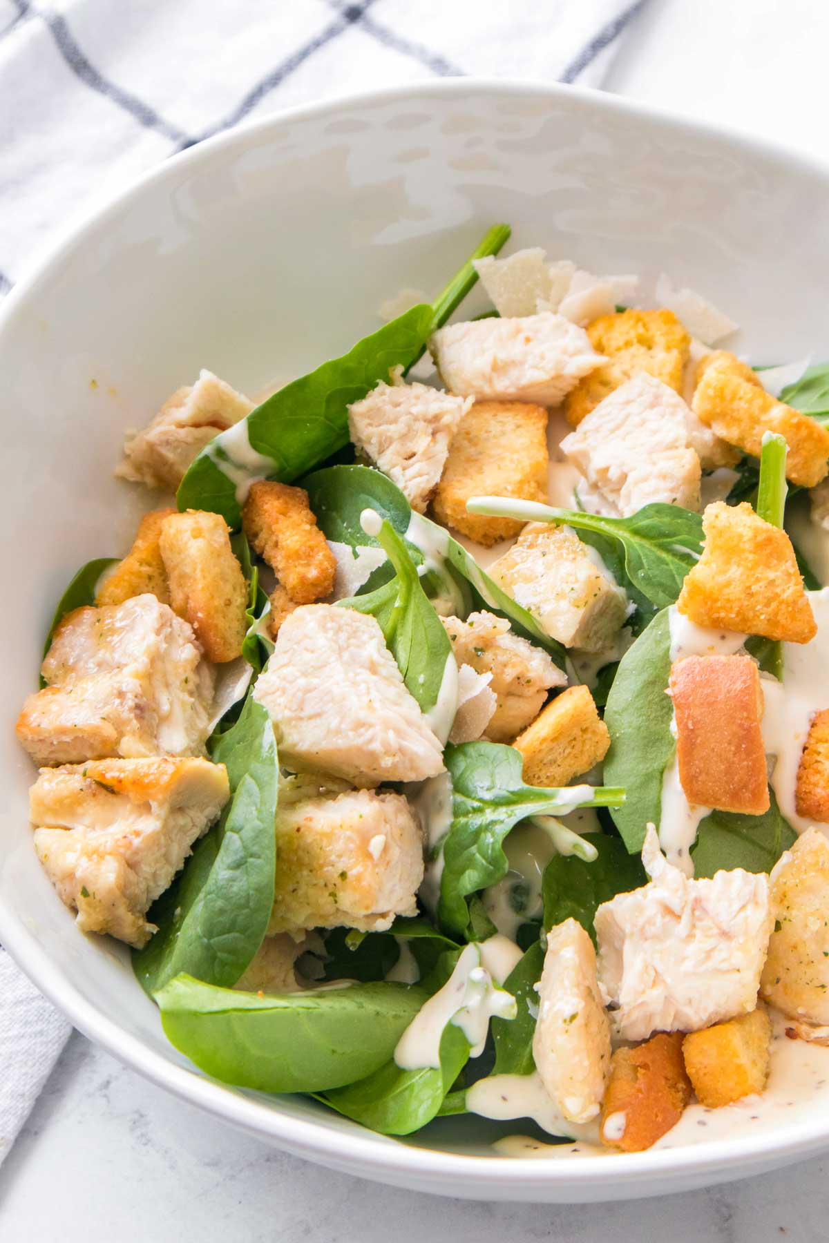 Bowl of spinach Caesar salad with air fryer chicken breast