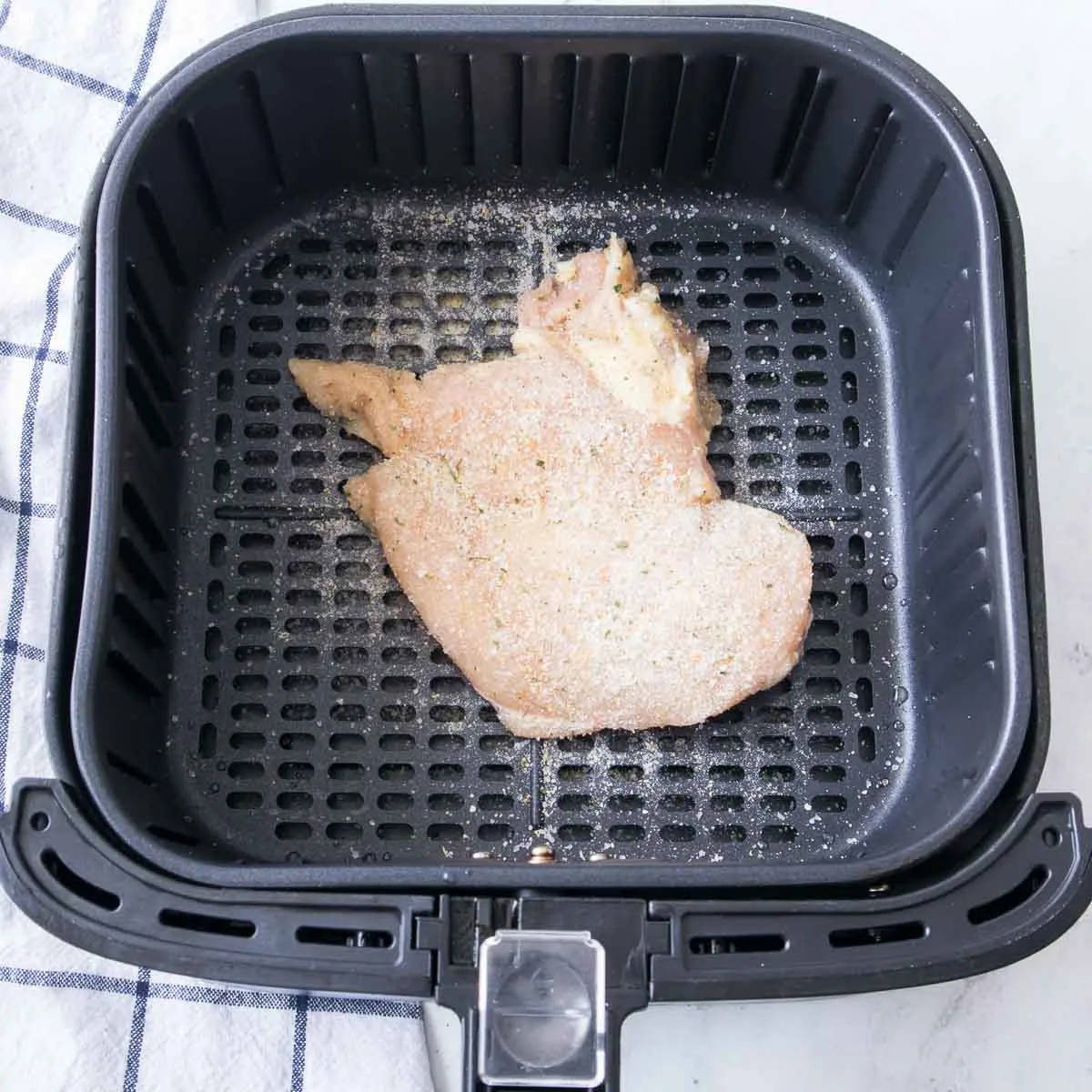 Chicken breast seasoned with garlic salt in an air fryer