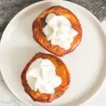 Air fryer peach halves topped with whipped cream