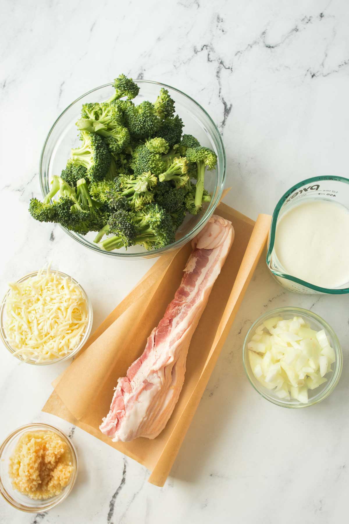 Ingredients to make bacon and broccoli in creamy garlic sauce