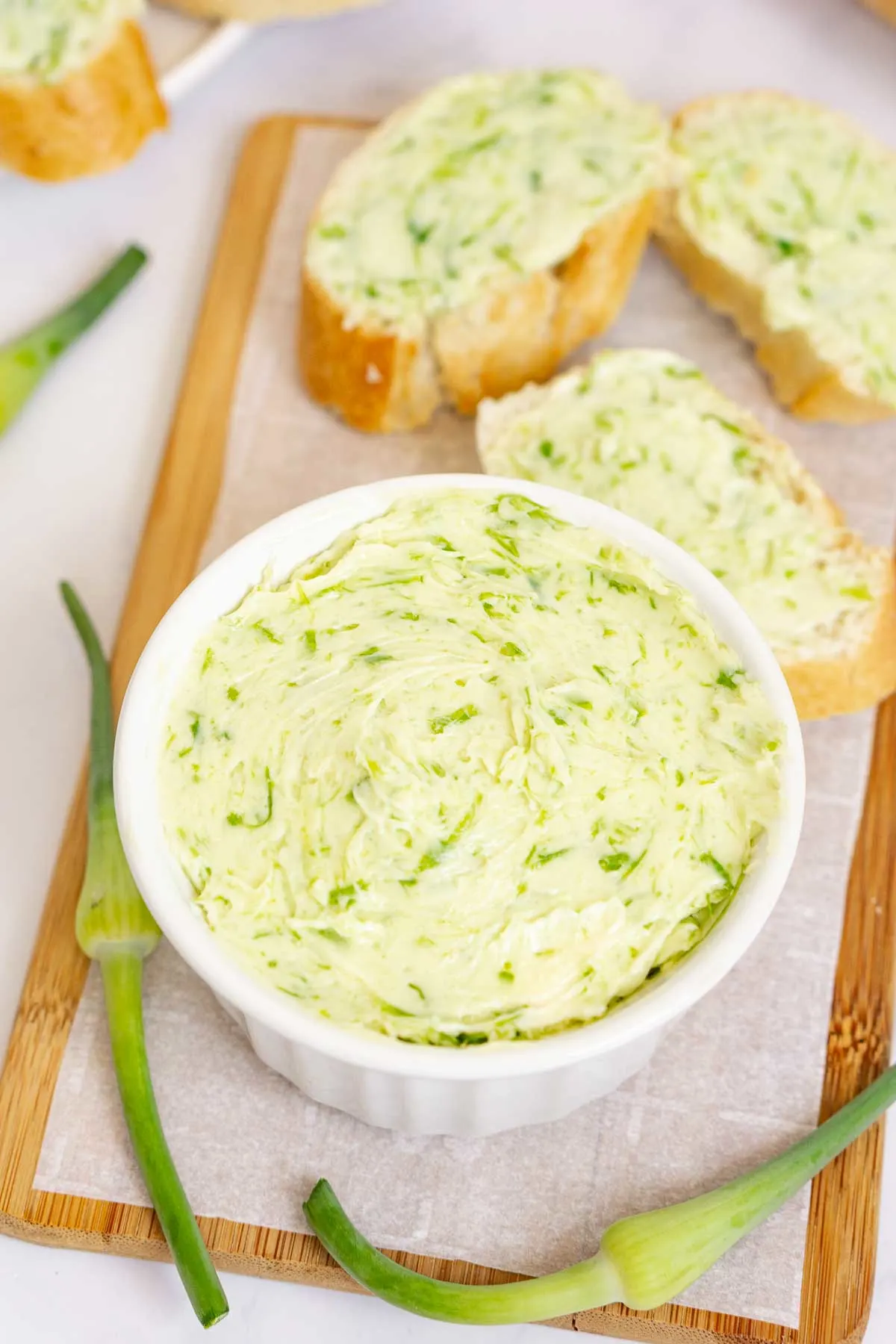 Garlic scape compound butter in a bowl with buttered toasts