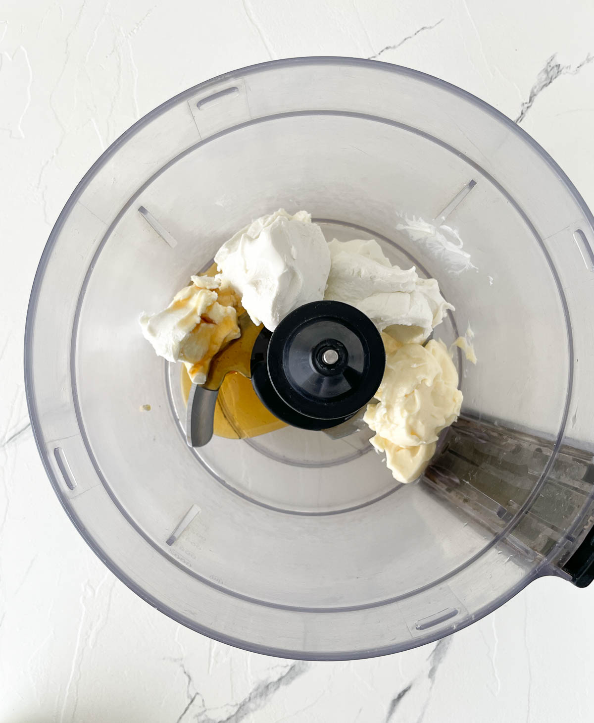 Goat cheese, cream cheese, and honey in a food processor.