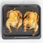 2 air fried Cornish hens on an air fryer tray