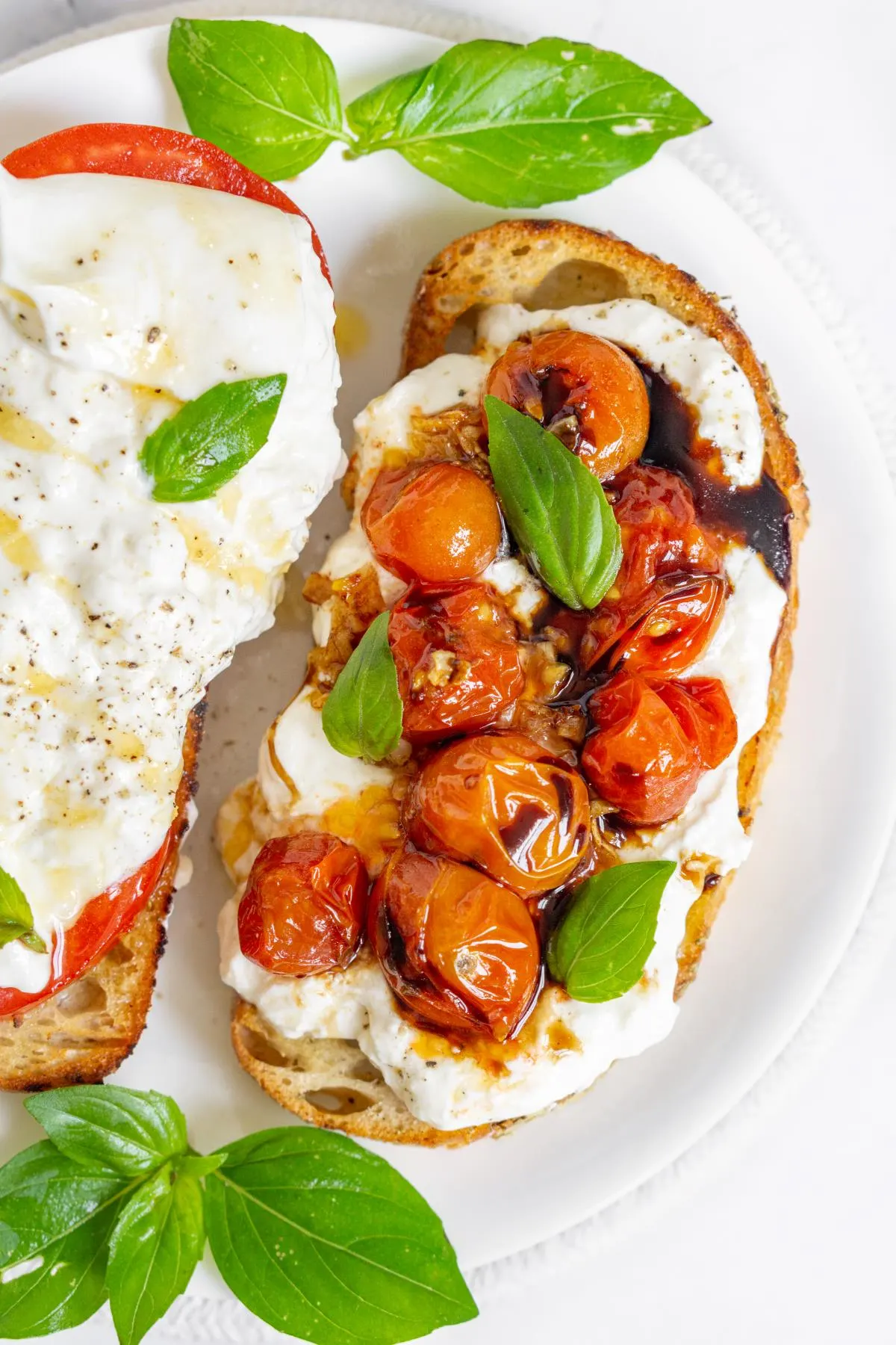 Close up of a burrata toast with blistered cherry tomatoes and basil