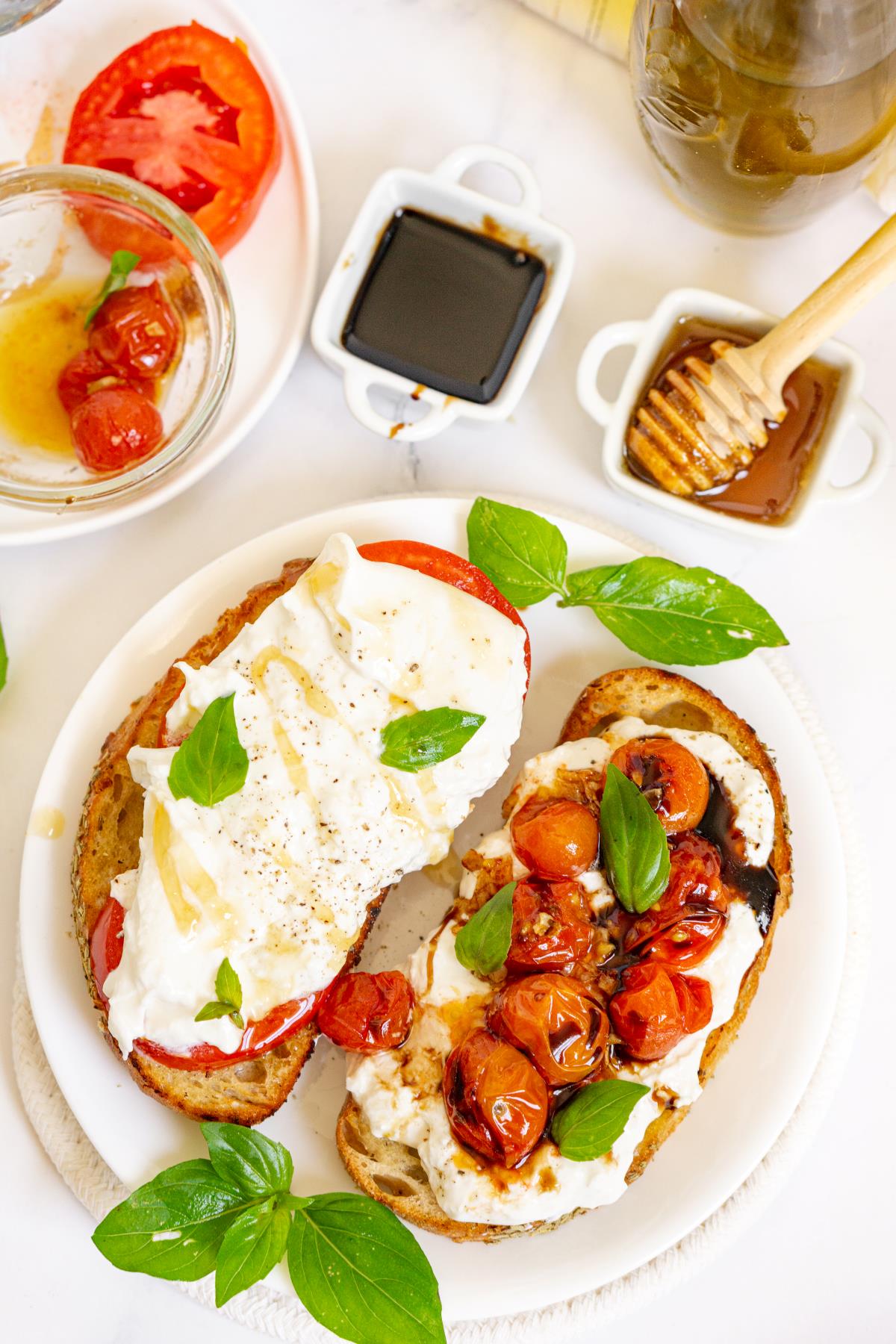 Plate of burrata toasts with toppings and garnishes on the side