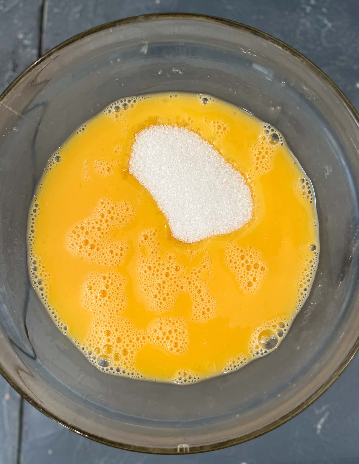 Adding sugar to a beaten egg