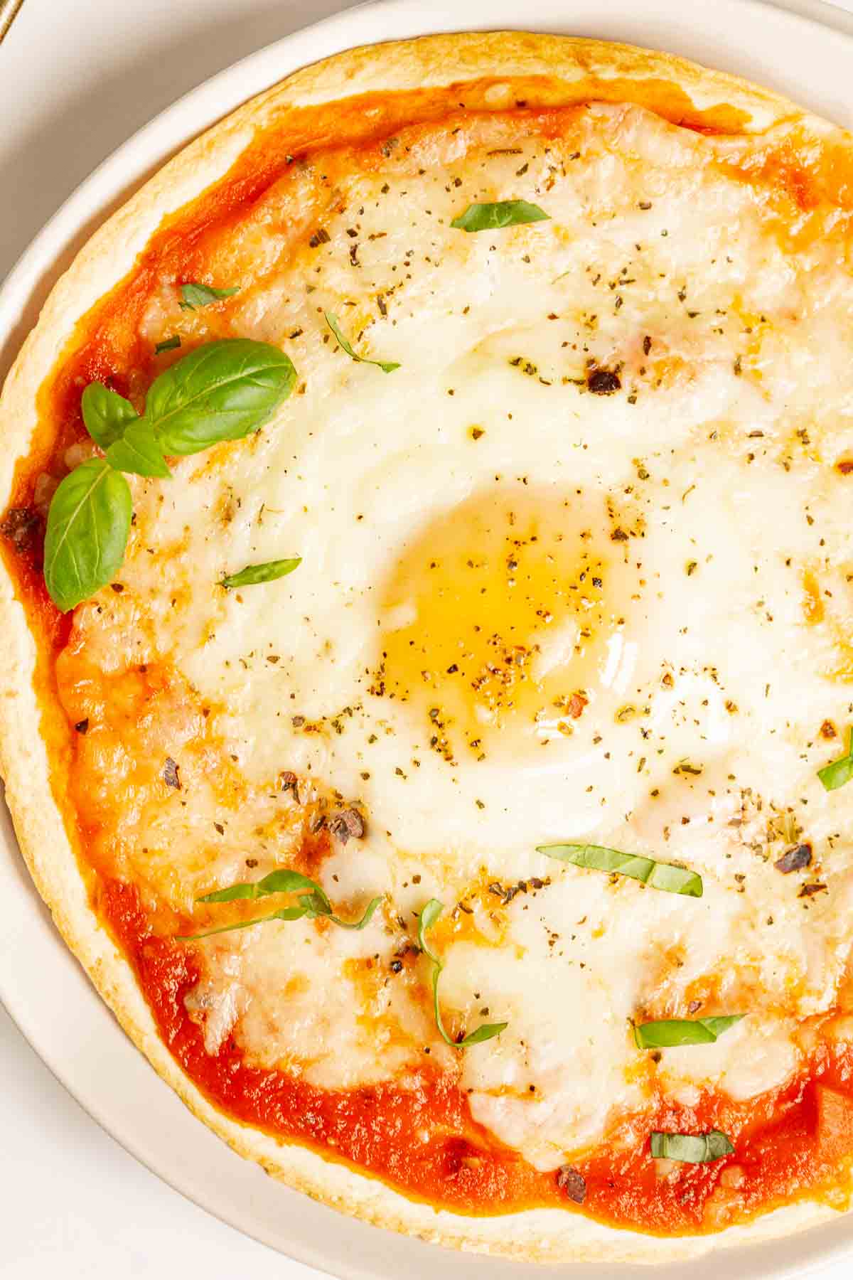 Breakfast tortilla pizza with a runny egg