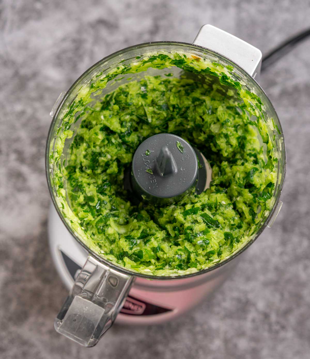 Food processor with finely minced parsley, onion, and garlic.