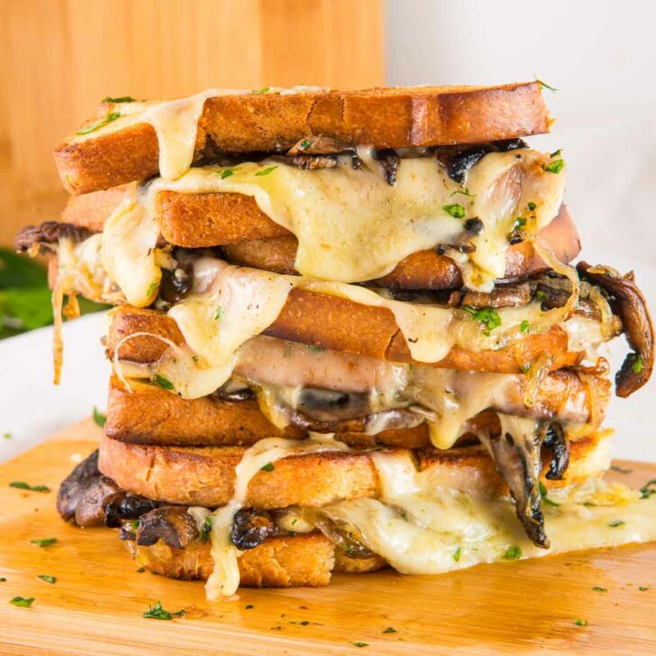 Two mushroom grilled cheese sandwiches stacked on top of each other