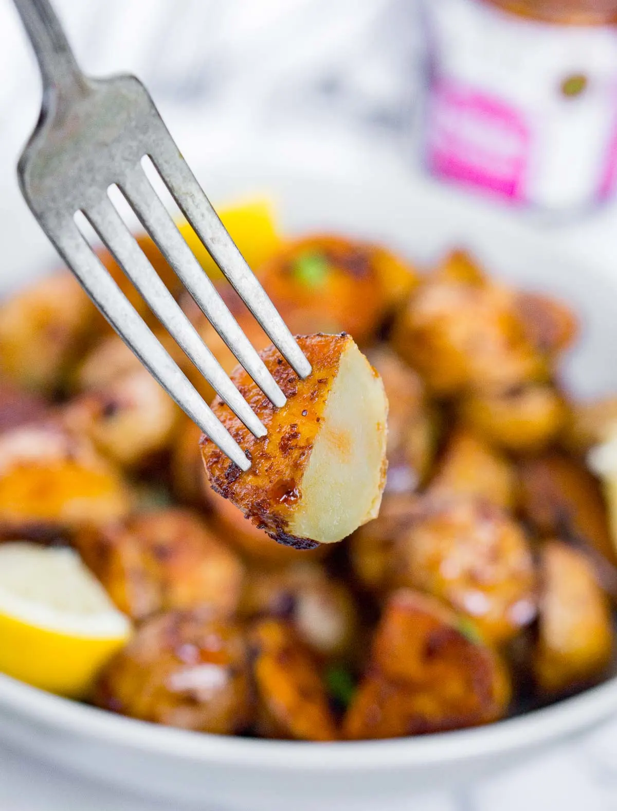 Fork holding a halved roasted potato to show texture