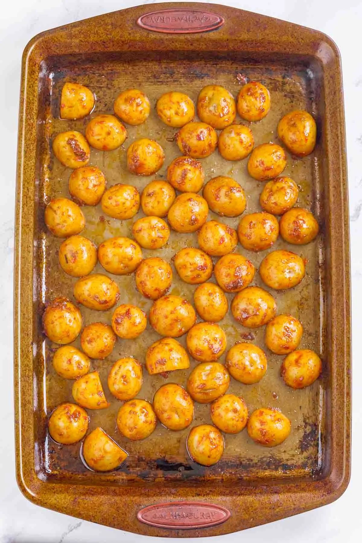 Potatoes seasoned with harissa arranged in a baking dish